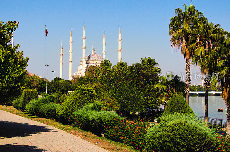 风景如画的萨班齐中央清真寺(土耳其:萨班齐Merkez Cami)和靠近塞汉河的城市公园在阿达纳。树叶边界。自然坐标系。旅游概念
